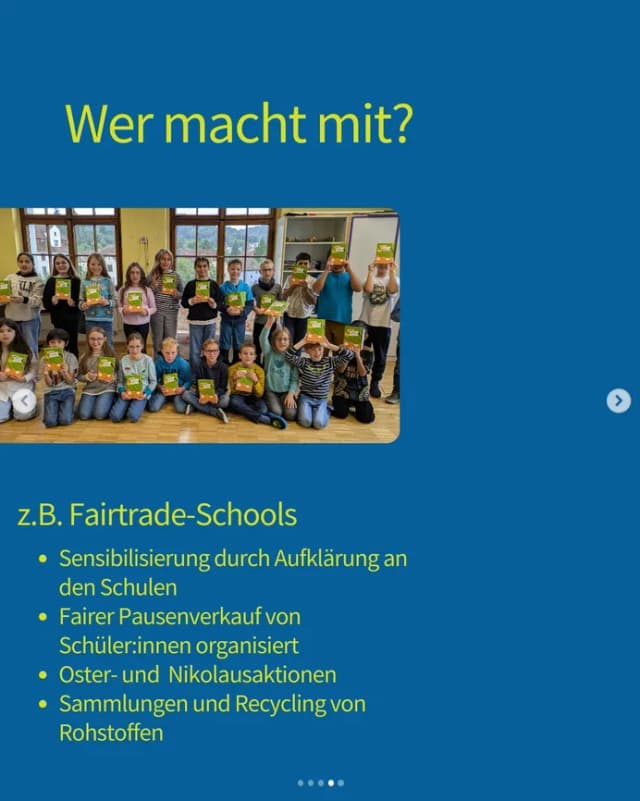 Schulklasse steht in einem Klassenzimmer und hält Fairtrade-Produkte in die Höhe