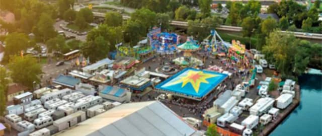 Luftaufnahme der Lohrer Spessartfestwoche mit Fahrgeschäften, Zelten und Wohnwagen entlang des Mains