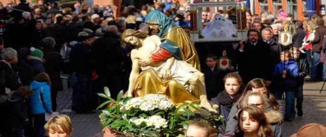 Prozession mit Pietà-Figur auf Blumenschmuck, umgeben von zahlreichen Menschen bei einer Karfreitagsprozession in Lohr am Main