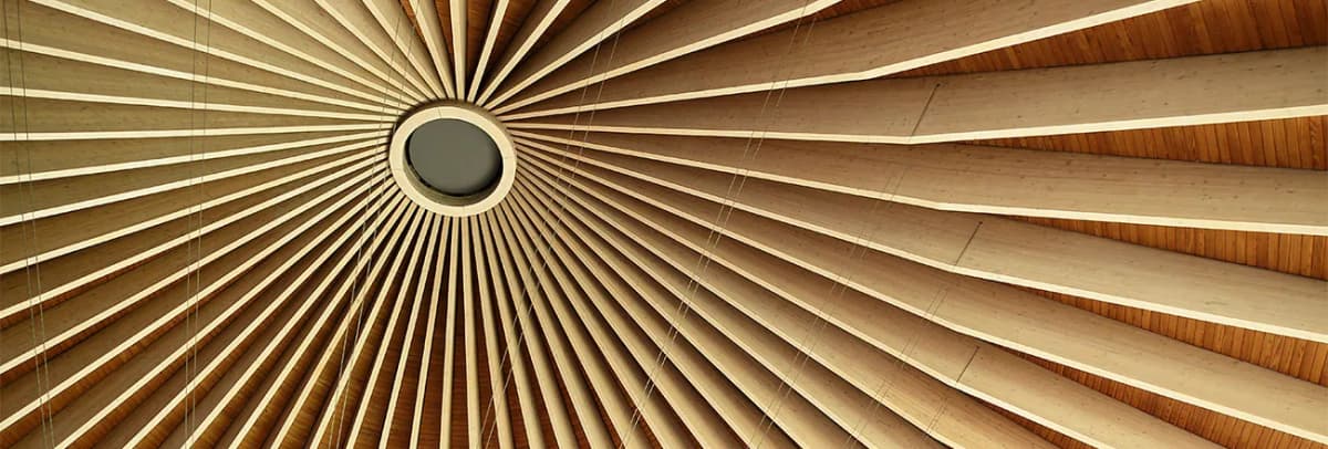 Holzdachkonstruktion einer Kirche mit sternförmig angeordneten Balken um eine runde Dachöffnung