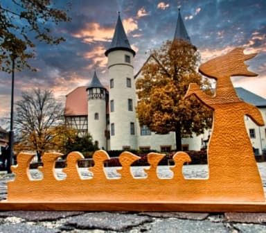 Eine Holz-Figur des Horrorwittchens steht vor dem Schloss in Lohr am Main.