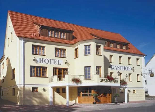 Gelbes Gebäude mit rotem Ziegeldach und Balkon, Hotel Gasthof Spessarttor