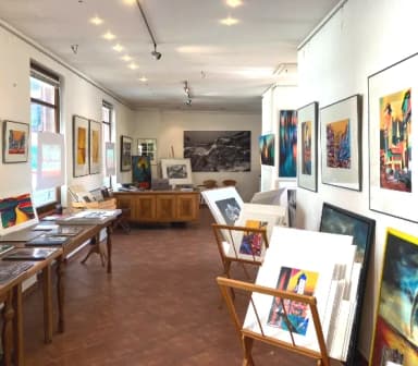 Blick in eine Kunstgalerie mit einer Ausstellung von Fotografien und Bildern