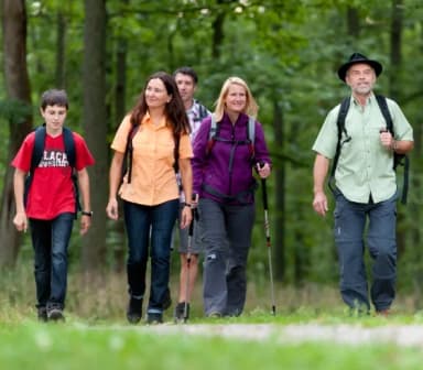 Eine Gruppe von fünf Personen Wandern auf einem Waldweg