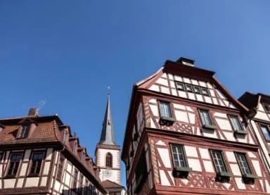 Fachwerkhäuser und Kirchturmspitze vor blauem Himmel in der Altstadt