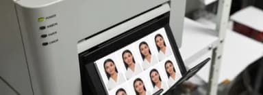 Fotodrucker mit ausgedrucktem Bogen aus mehreren Passbildern für einen Ausweis