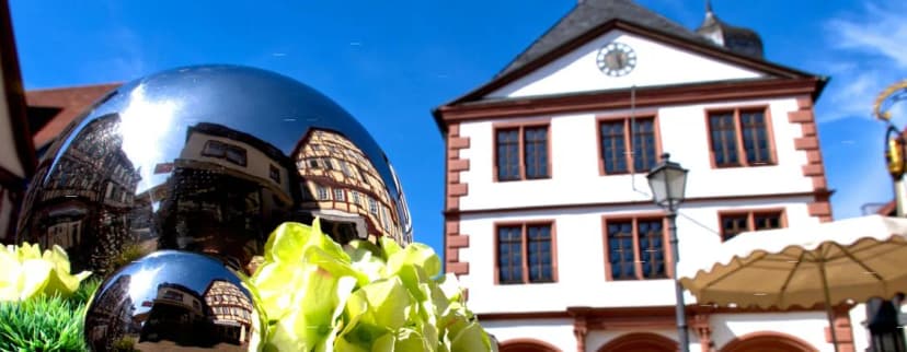 Spiegelkugeln mit Fachwerkreflexion vor dem Rathaus mit Turmuhr