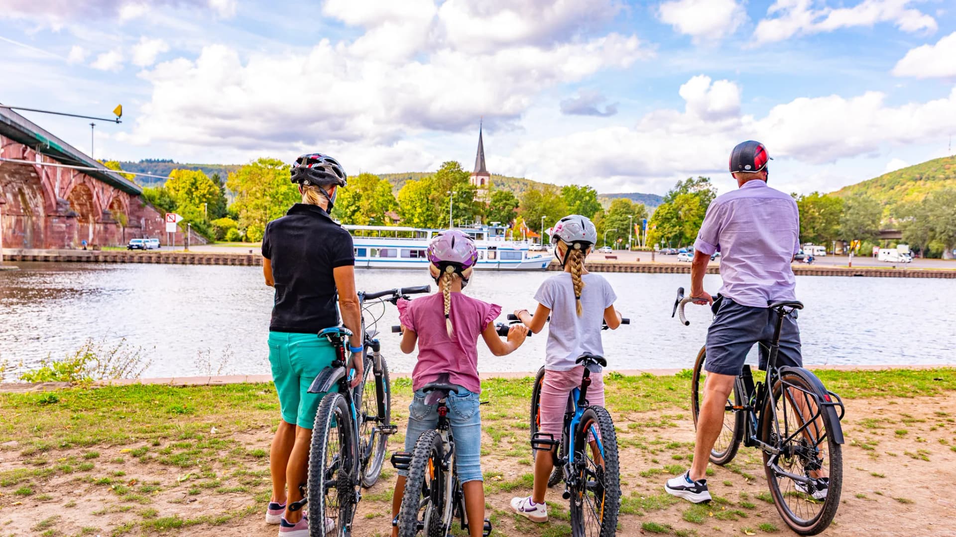 Eine Familie blickt Richtung Main in Lohr. Sie macht eine Pause bei ihrer Radtour.