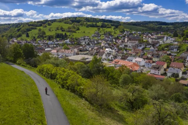 Eine Spaziergängerin läuft an Frammersbach vorbei