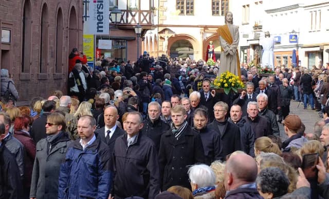 Prozession mit Heiligenfiguren durch eine mit Menschen gefüllte Altstadtgasse an Karfreitag in Lohr am Main