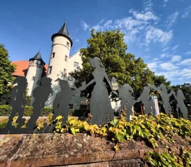 Blick auf die Silhouette mit Schneewittchen und ihren sieben Zwergen vor dem Schloss in Lohr am Main